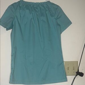 Women's green scrub top is cute with baby doll collar.